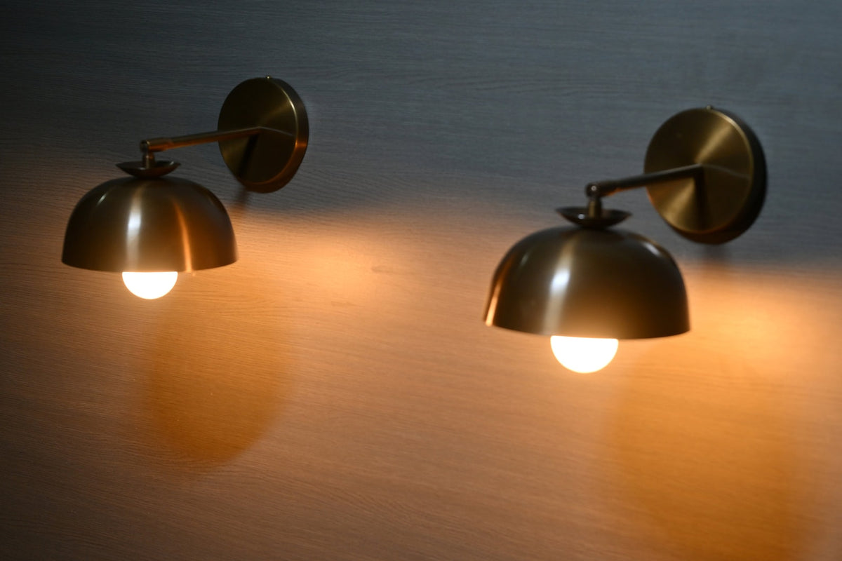 Brass dome shade wall sconces illuminated with warm ambient glow – lit view