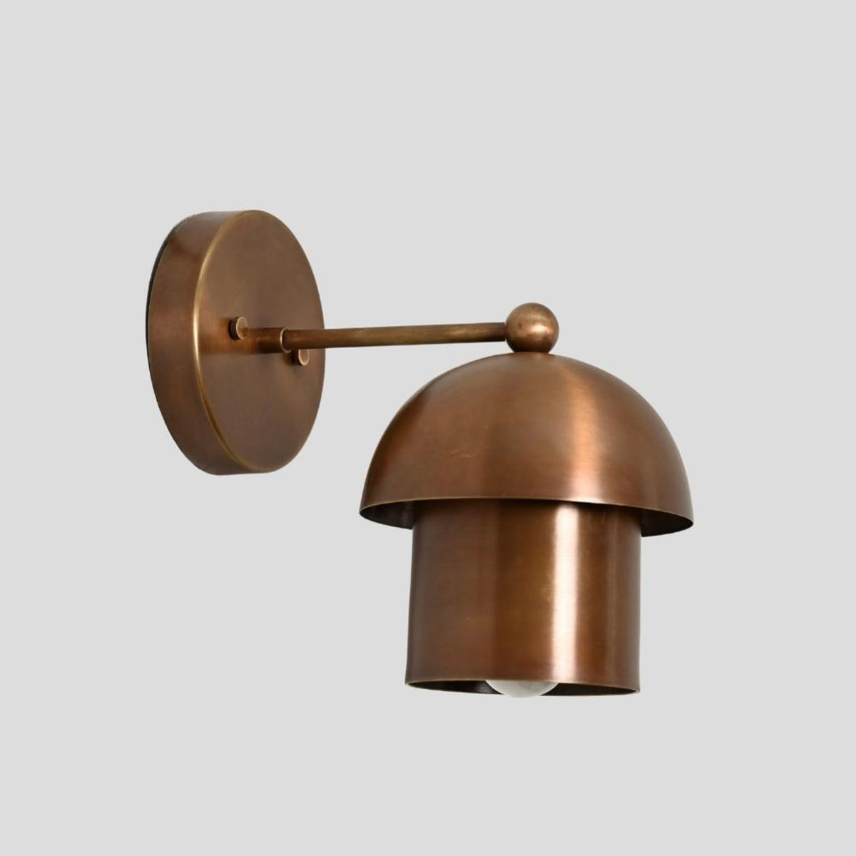 Vintage-inspired brass dome wall sconce with industrial design and warm lighting
