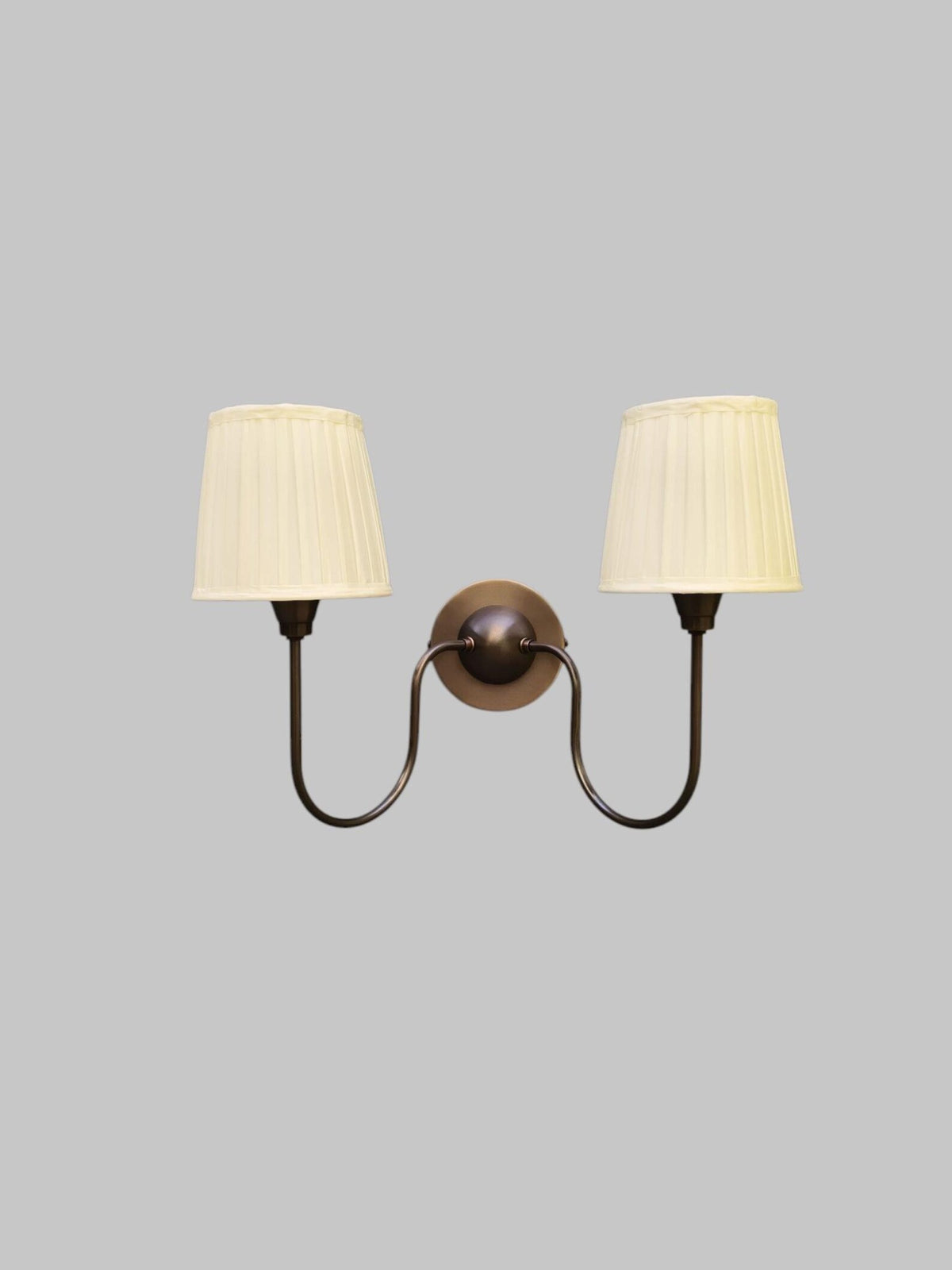 Double arm wall sconce in blackened brass finish with pleated shades – front view
