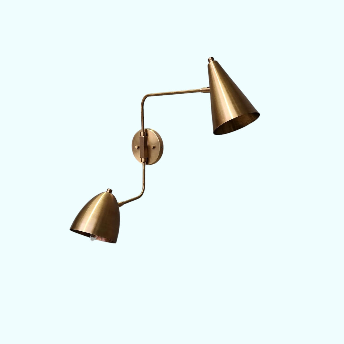 djustable brass wall sconce with dual cone shades – angled perspective