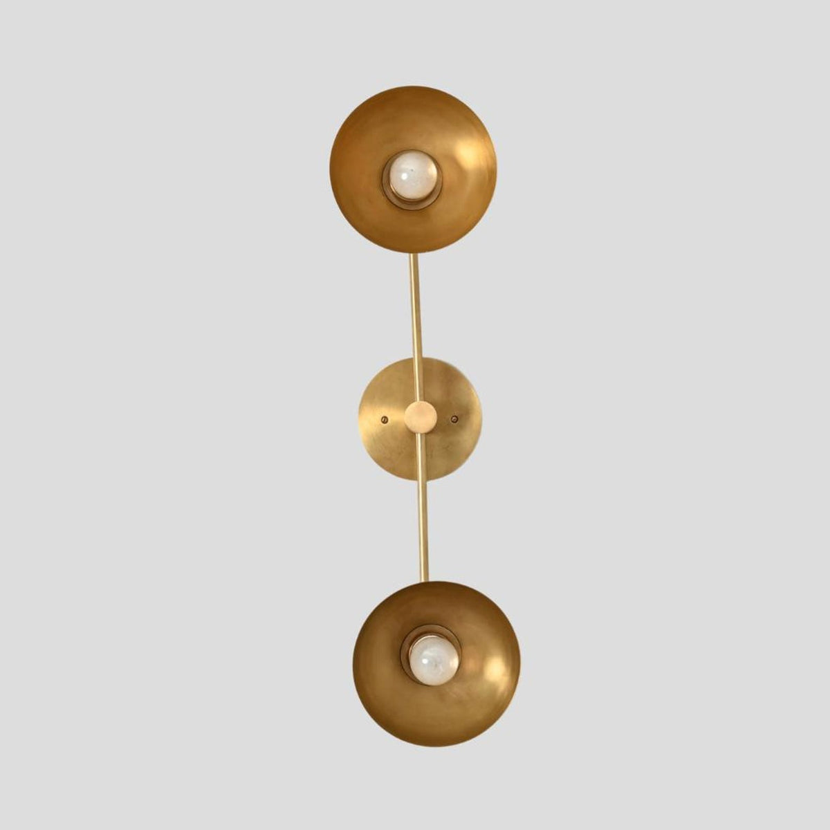Straight vertical view of brass double wall sconce with symmetrical bowl shades and central brass mount, designed for modern interiors.
