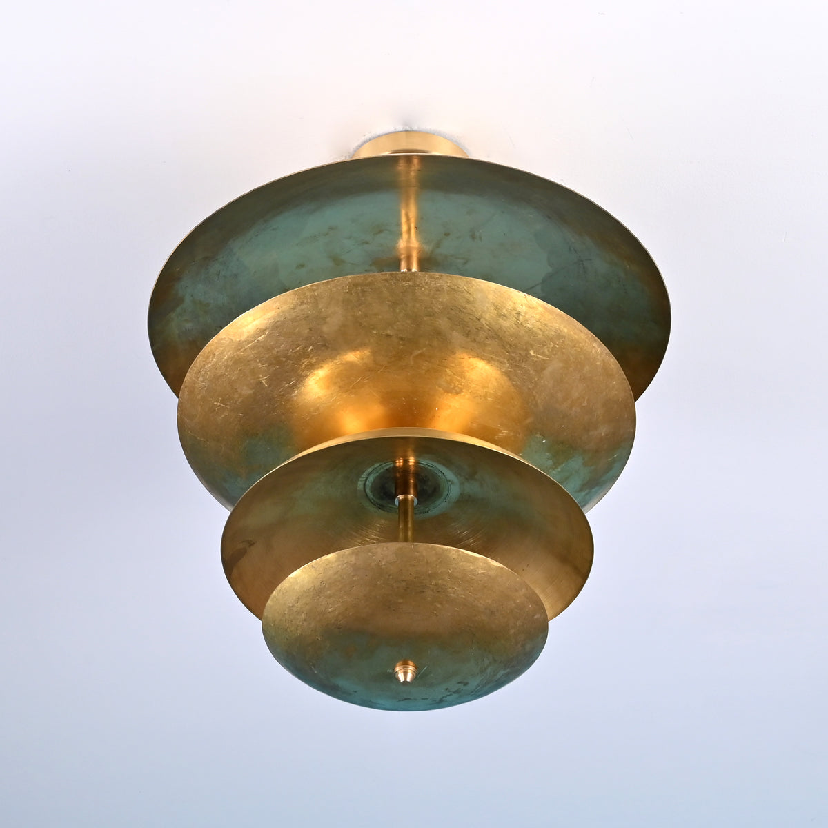 Bottom view of layered brass flush mount ceiling light showing concentric disc design and solid brass construction.