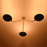 Three-light brass flush mount ceiling light creating warm ambient indirect lighting on ceiling
