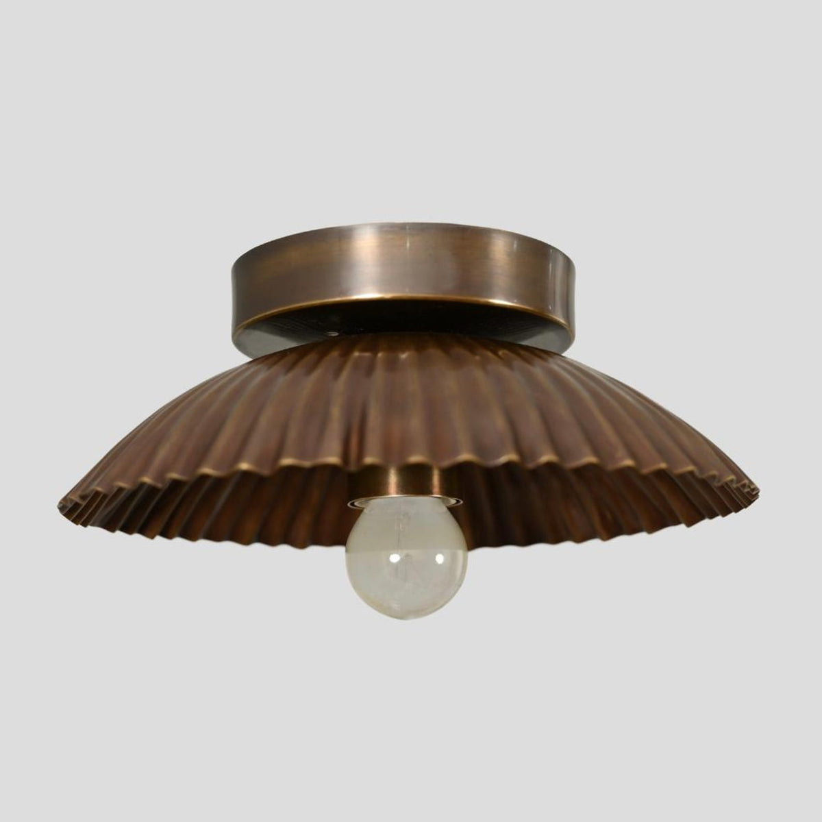 Front view of handcrafted brass scalloped flush mount ceiling lamp with bulb