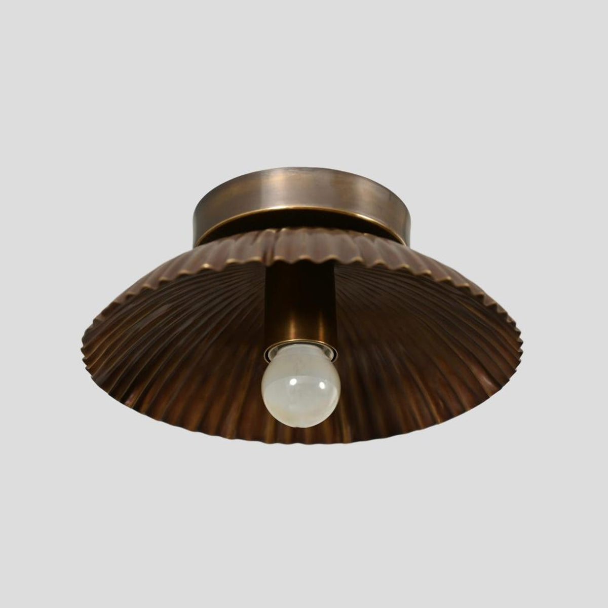 Side view of scalloped brass ceiling light fixture in antique brushed finish
