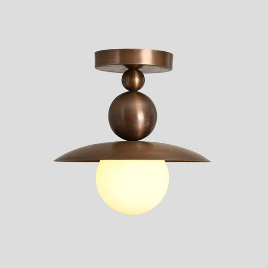 Handmade brass flushmount ceiling light with sculptural globe shade and dome reflector, designed by Brass Leaf Studio for modern and industrial interiors.