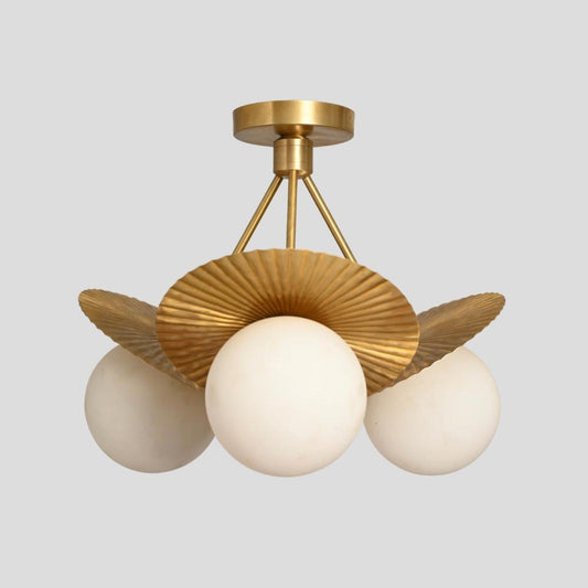 Handmade brass ceiling chandelier featuring three round frosted globes and ribbed fluted brass disc shades for a modern elegant look.