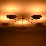 Warm ambient lighting effect from brass flushmount chandelier with bowl shades illuminating the ceiling.