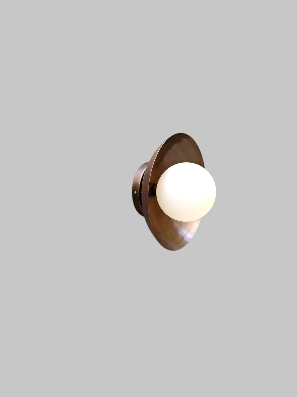 Minimalist handmade brass flush mount light with frosted globe, perspective view