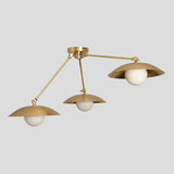 Modern industrial brass flushmount chandelier with three bowl-shaped brass shades and spherical bulbs, angled side view.
