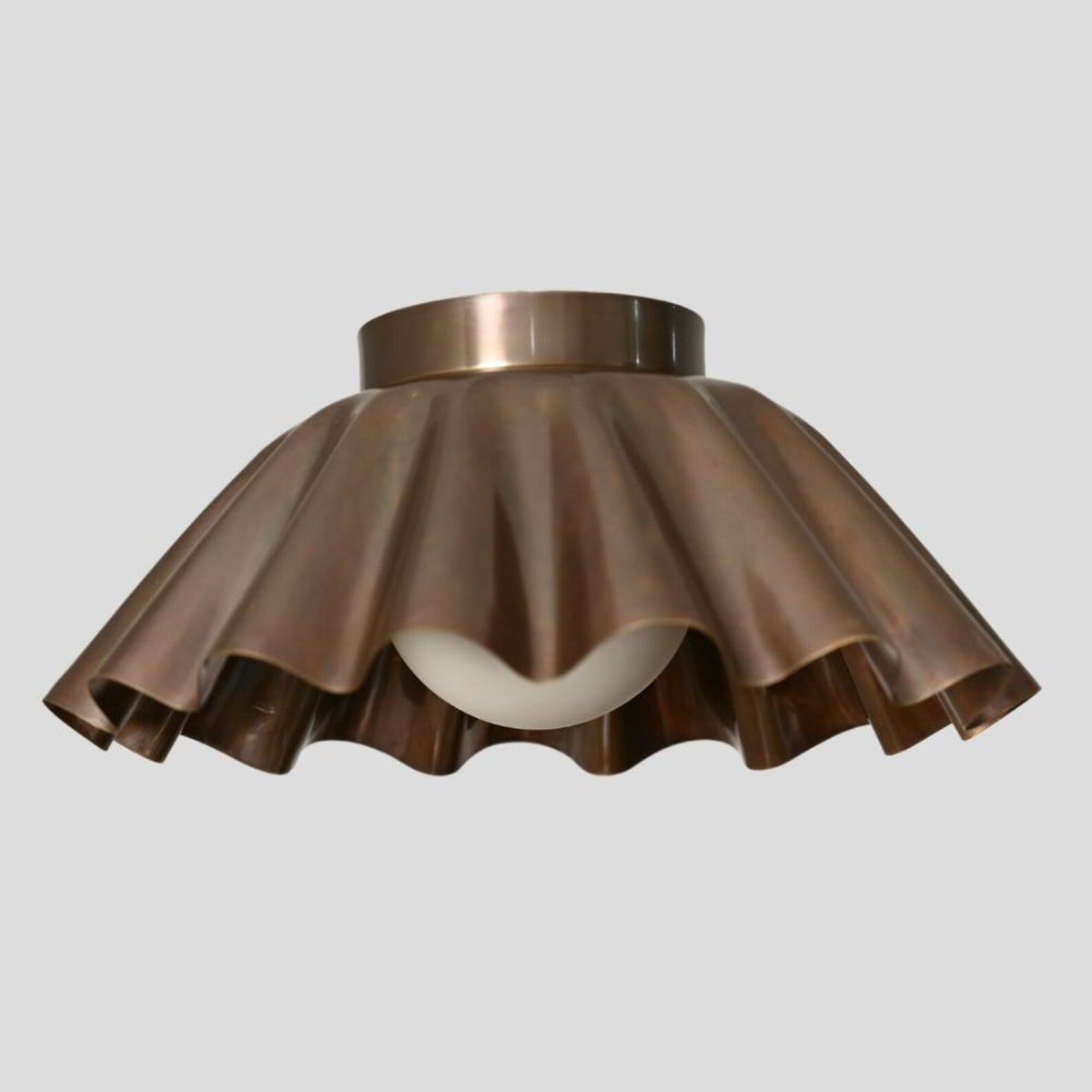 Modern sculpted brass ceiling light in flush mount style featuring industrial-grade brass and warm ambient glow.