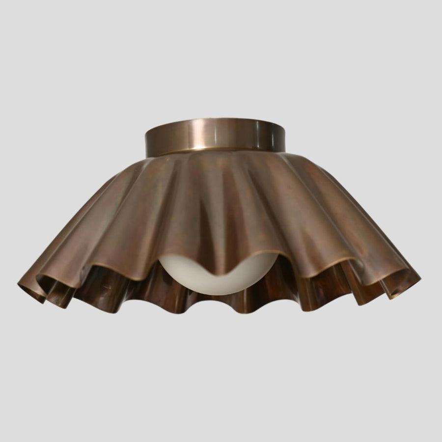 Handmade brass flush mount ceiling light with sculpted ruffle shade and frosted bulb by Brass Leaf Studio.