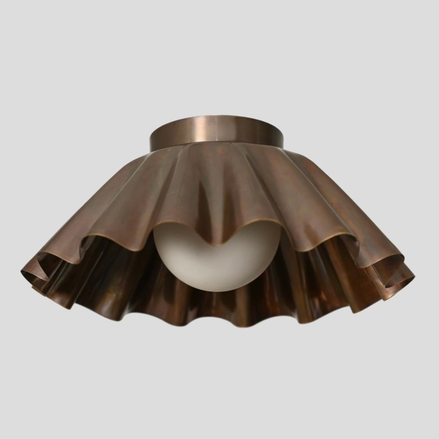 Handmade brass flush mount ceiling light with sculpted ruffle shade and frosted bulb by Brass Leaf Studio.