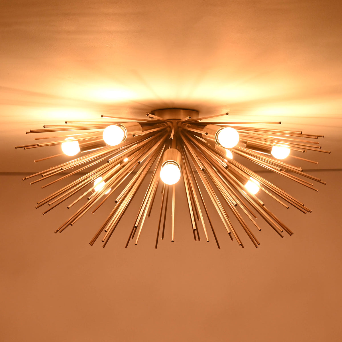 Warm glowing brass flushmount chandelier with starburst rods and bright bulbs
