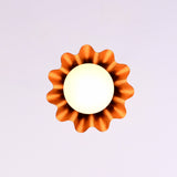 Bottom view of modern brass fluted disc pendant light with glowing glass globe and warm ambient illumination.