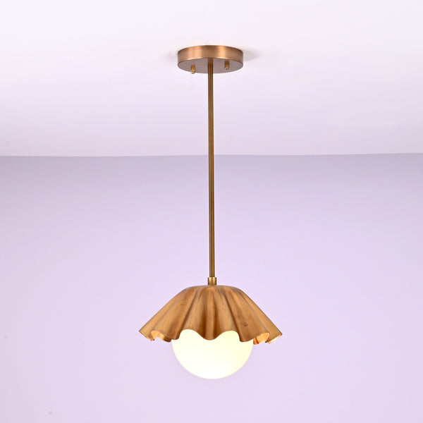 Minimalist brass fluted pendant light hanging straight with sculpted shade and glowing globe.