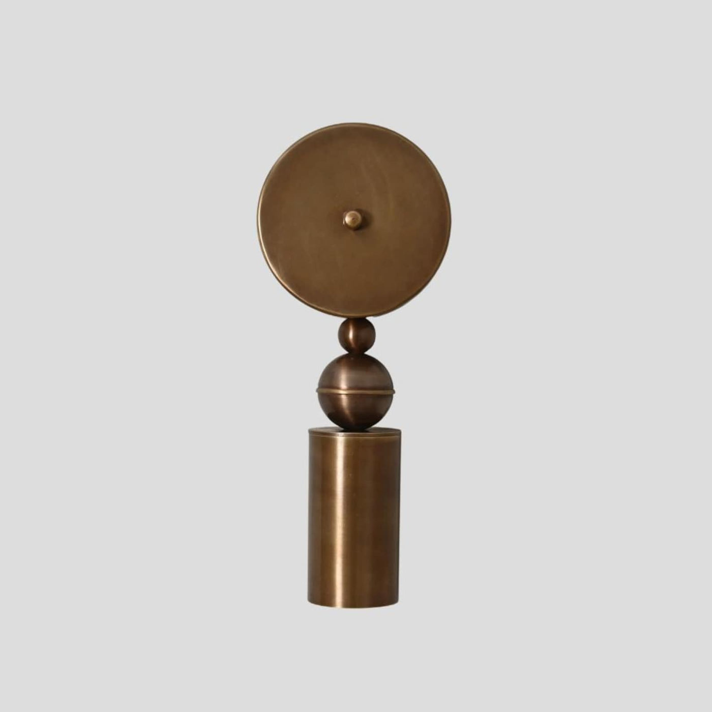 Handmade brass wall sconce with geometric cylinder and sphere design, modern minimalist lighting fixture front view