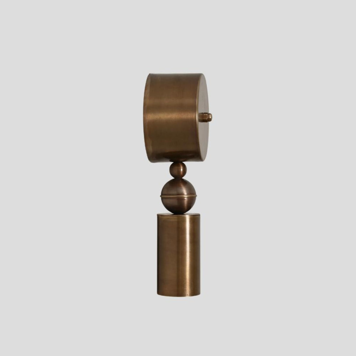 Solid brass wall sconce with geometric cylinder and sphere design, minimalist modern wall light side view