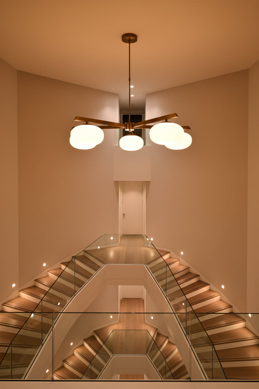 Brass oval glass ball chandelier installed in a warm interior with five glowing opal shades and balanced linear design