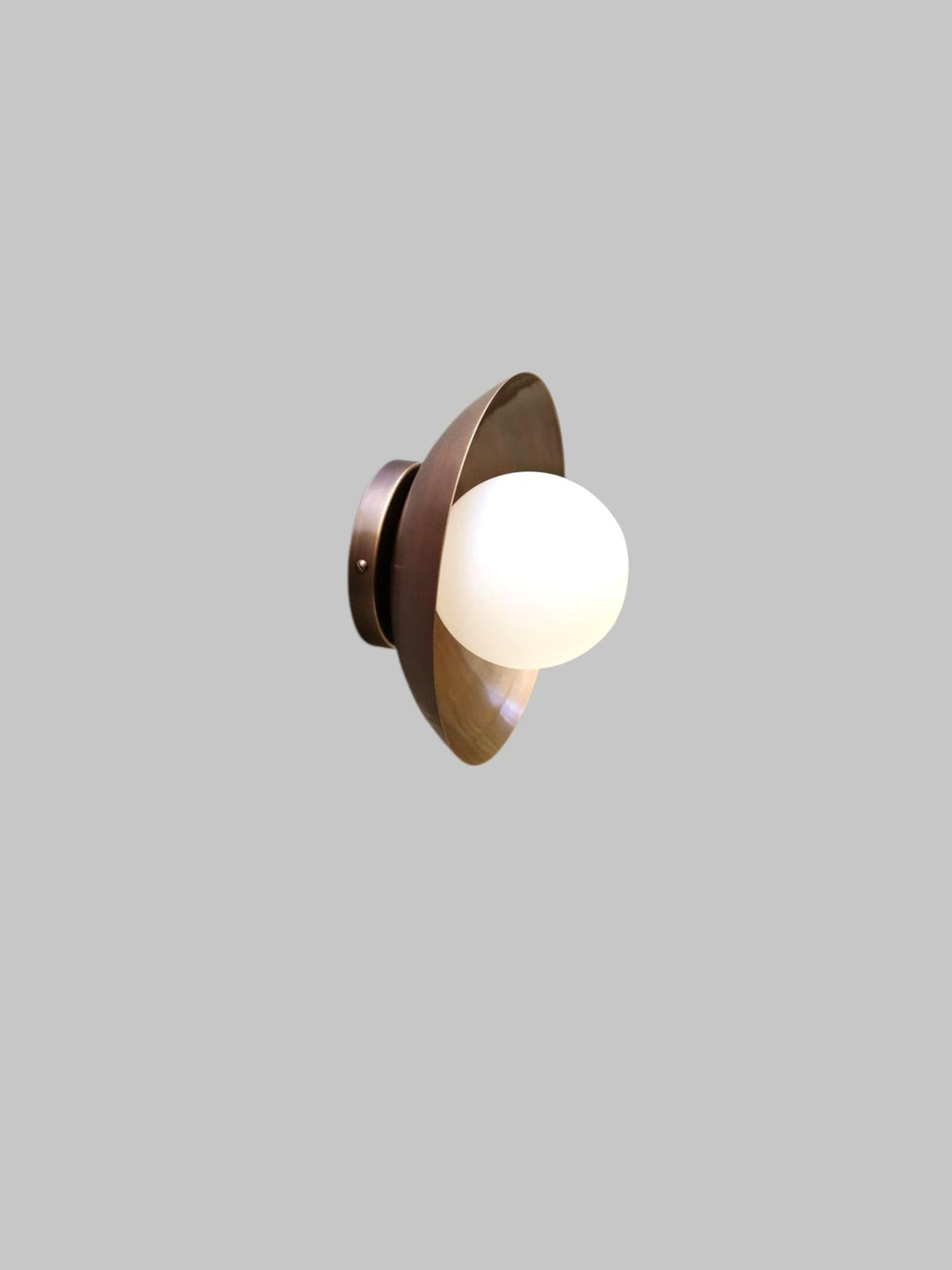 Modern brass ceiling light with frosted glass globe, side angled view