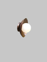 Modern brass ceiling light with frosted glass globe, side angled view
