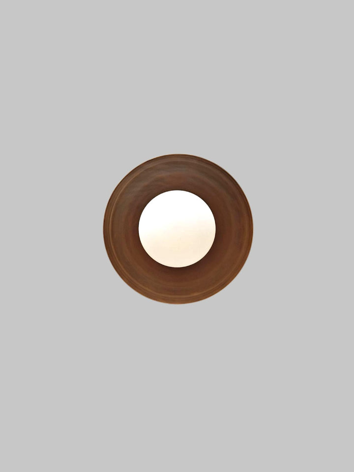 Top view of handcrafted brass flush mount light with white glass globe