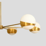 Close-up of brass chandelier globe shade, opal glass and brushed brass detail.