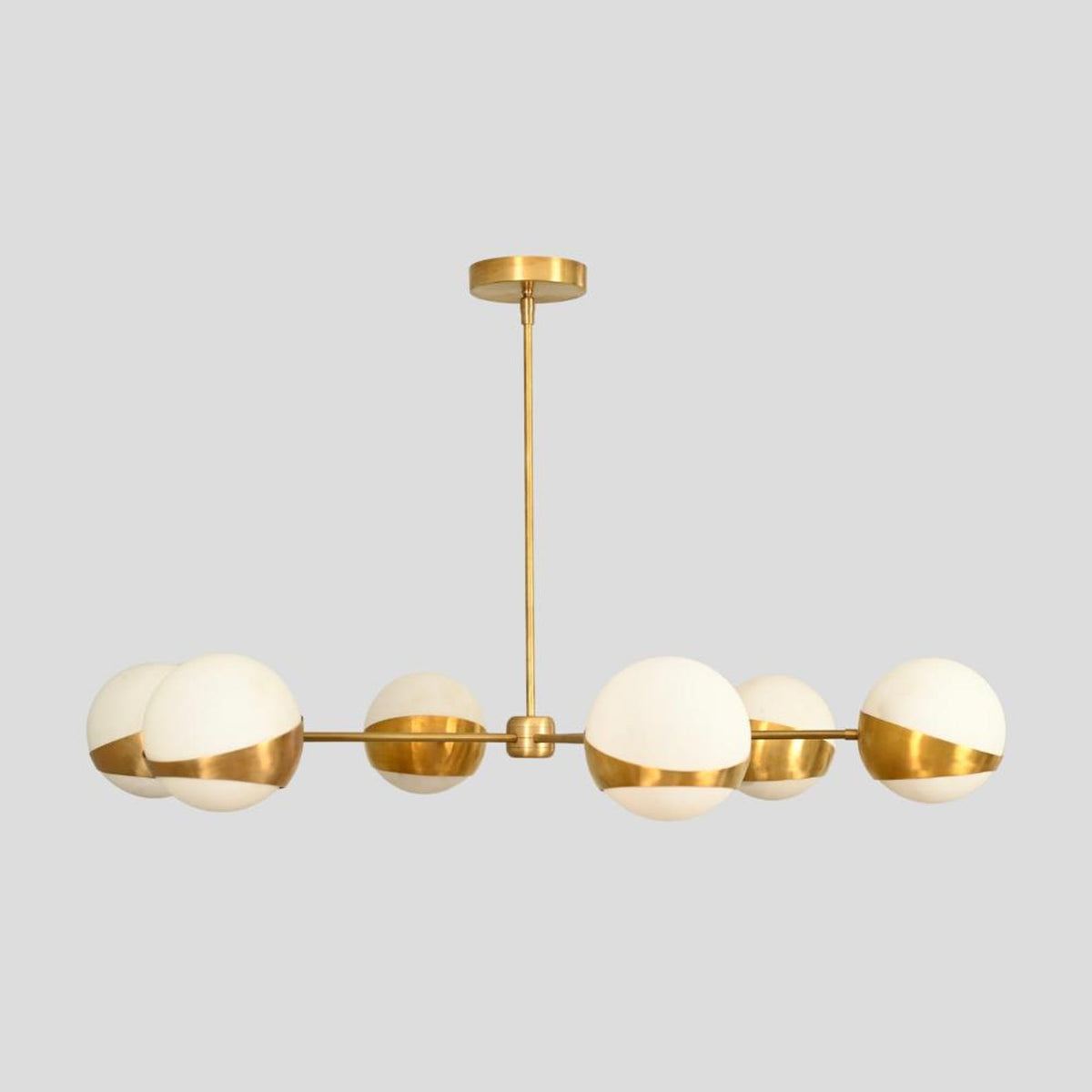 Handmade brass chandelier side profile with six globe lights in brushed brass and opal glass.
