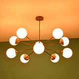 Modern brass globe chandelier illuminated with warm ambient lighting, ideal for dining rooms and living spaces.