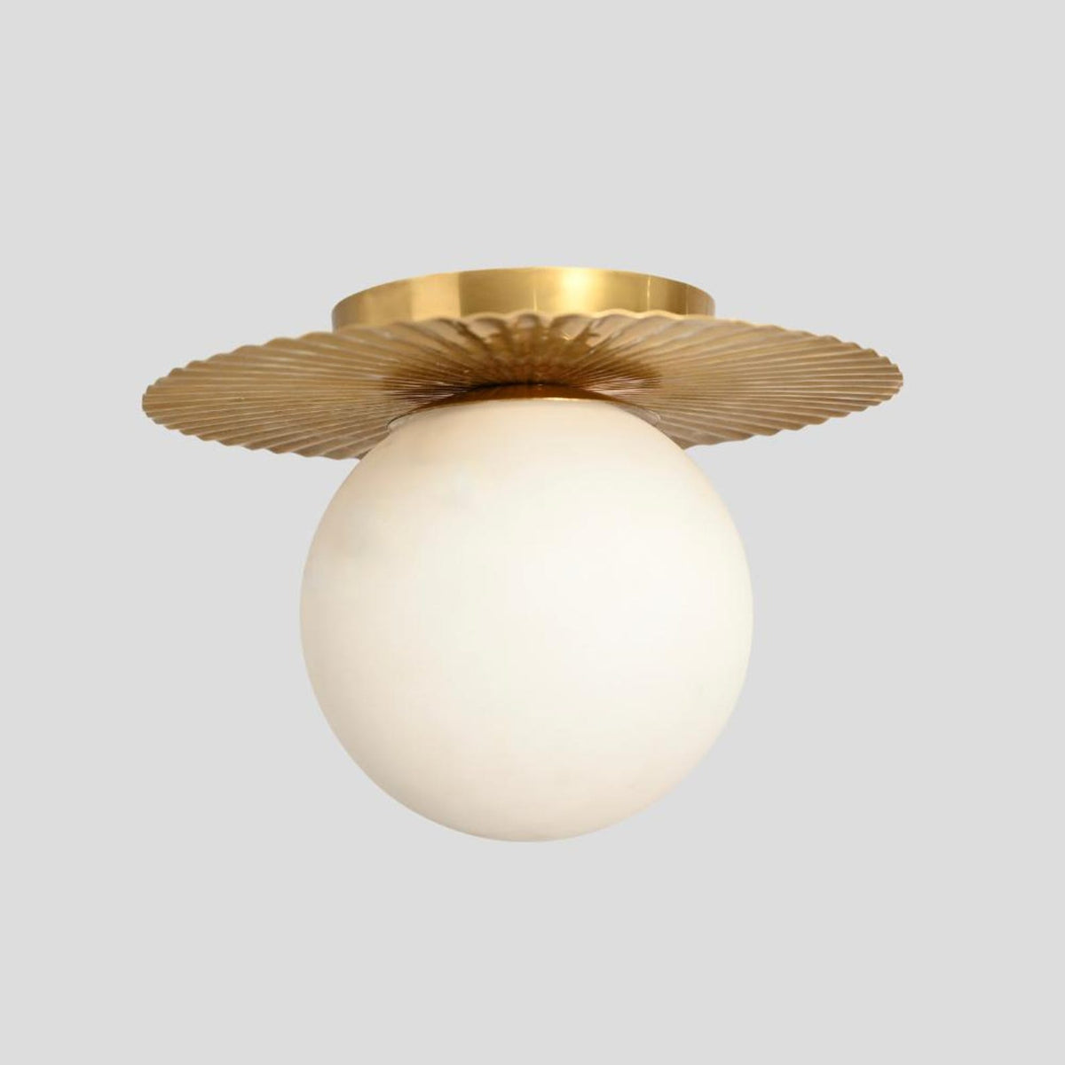 Front angled view of handmade brass ceiling light with round frosted globe and vintage brass detail