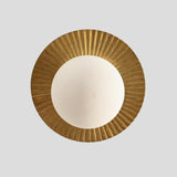 Top view of brass flush mount ceiling light with circular fluted brass plate and frosted glass globe