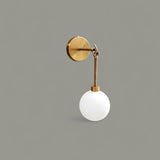Front view of solid brass wall sconce featuring frosted glass globe shade and elegant brushed brass finish