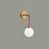 Side view of handmade brass wall sconce with frosted glass globe – minimalist modern wall light