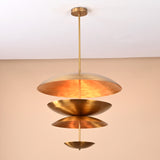 Layered brass disc chandelier with open illuminated shade revealing warm reflective inner brass finish.