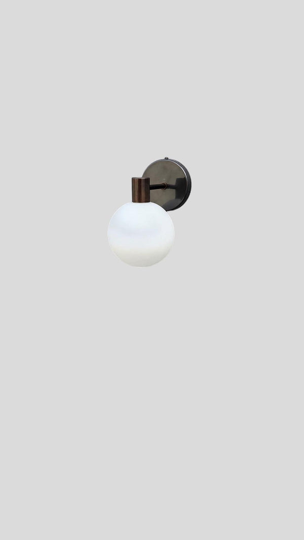 Front view of modern brass wall sconce with opal glass globe by Brass Leaf Studio