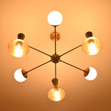 Bottom view of a 9-light brass chandelier featuring illuminated cone shades and opal globes arranged in a radial layout.