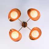 Bottom view of brass flush mount ceiling light showing four evenly spaced opal globe diffusers