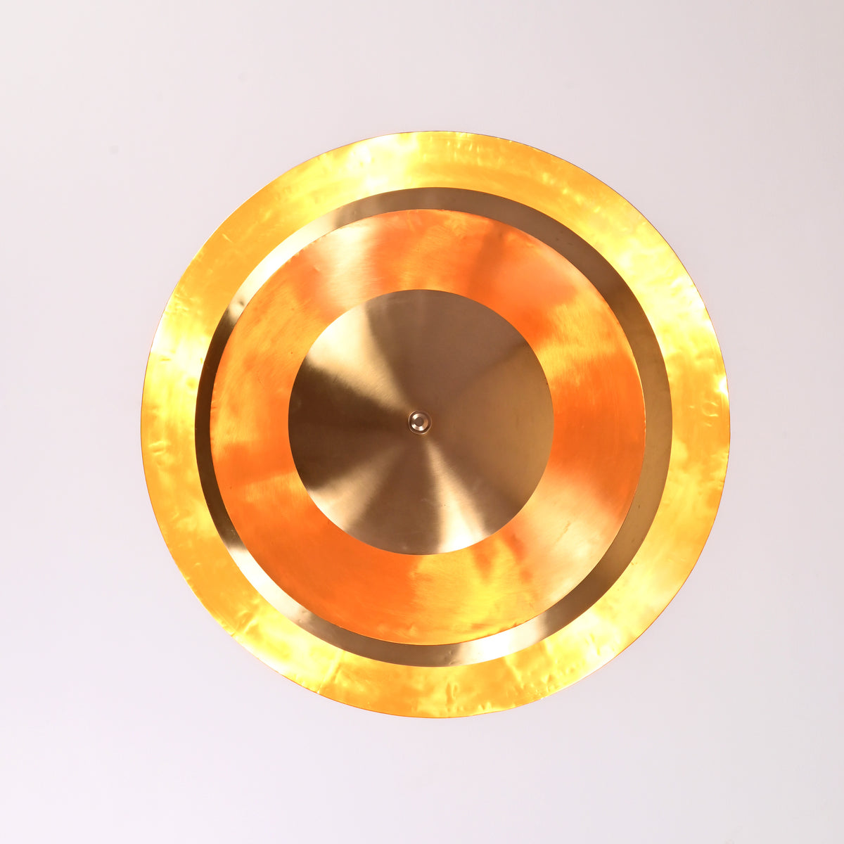Top view of handcrafted brass chandelier showing concentric circular design and polished glow