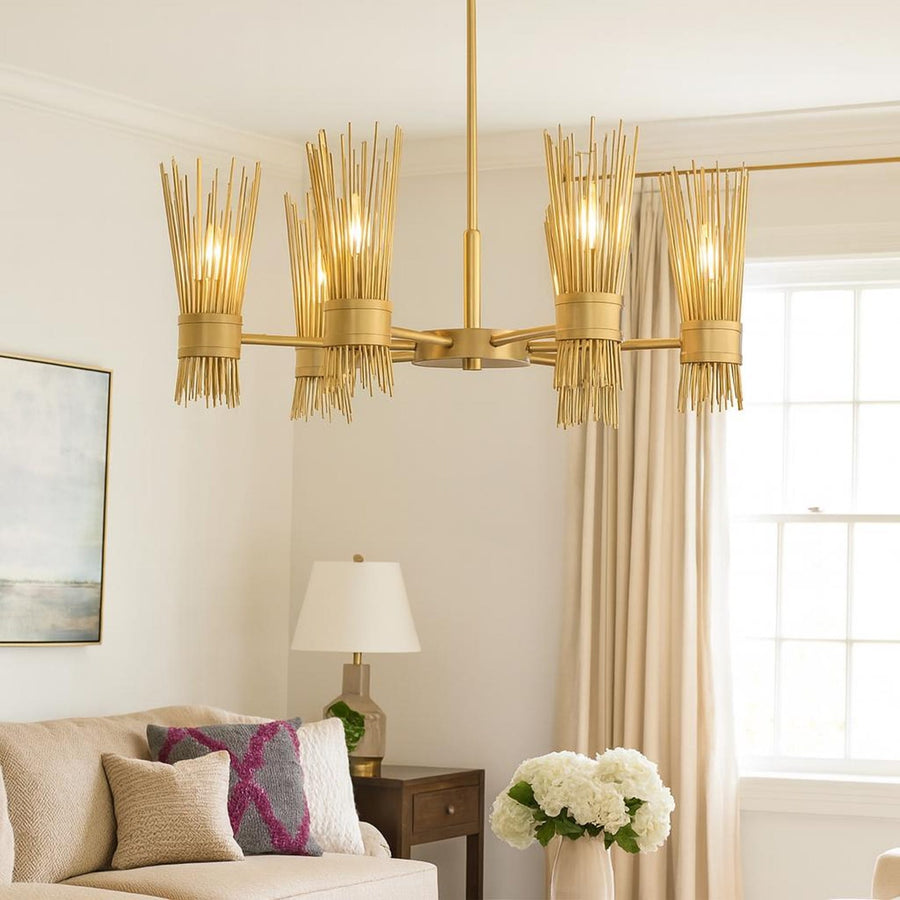 Six light sculpted brass reed chandelier in brushed brass finish hanging in a minimalist interior, showcasing warm ambient lighting and handcrafted metal detailing.