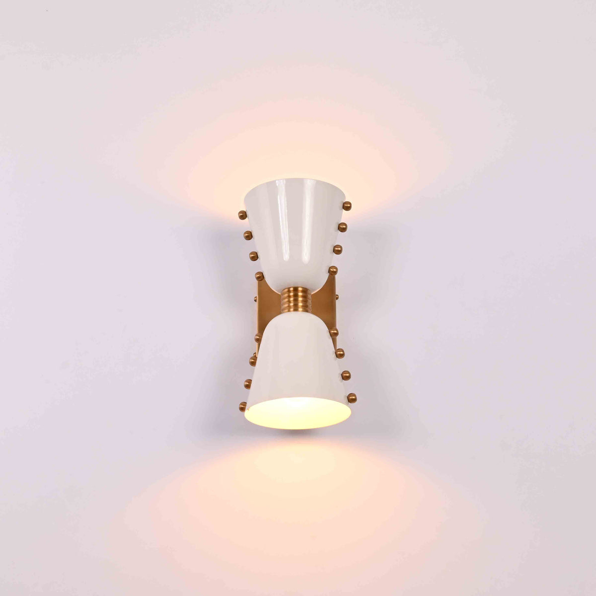 Brass Leaf Studio diabolo wall light with solid brass construction and elegant white cone shades