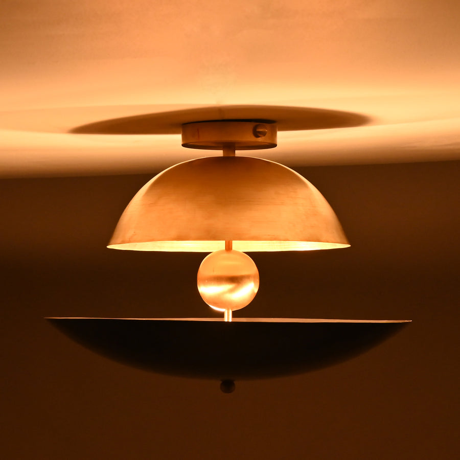 Two-tone dome and bowl flushmount chandelier featuring brushed brass and matte black shades with a sculptural brass sphere centerpiece.
