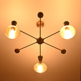Night-view of a mid-century modern brass chandelier with cone shades emitting soft ambient lighting.