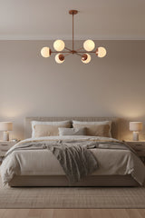 Brass Leaf Studio Monaco chandelier featuring six white glass globes and industrial grade brass construction