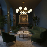 Brass Leaf Studio Naples chandelier featuring nine glass globes, brushed brass finish, and starburst design