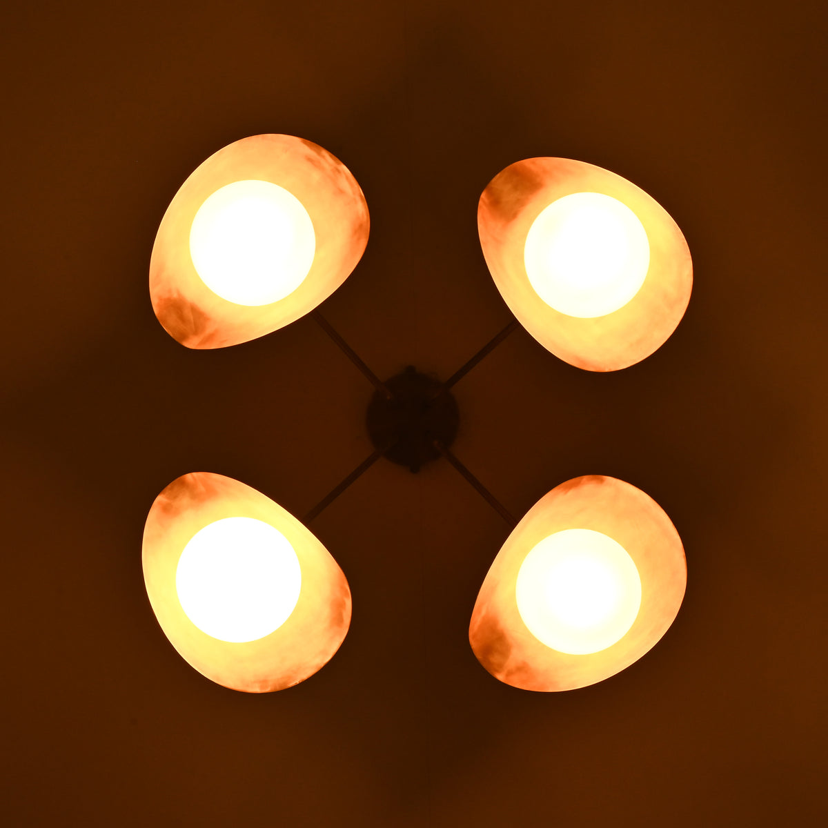 Night bottom view of opal globe brass ceiling light casting soft indirect lighting