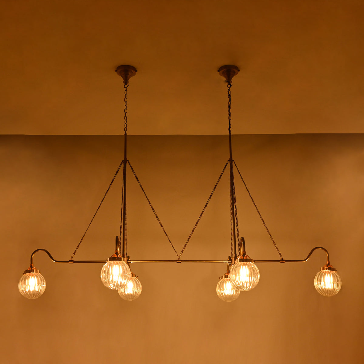 Brass Leaf Studio ribbed glass globe chandelier with six lights, brass frame, and luxury statement ceiling design