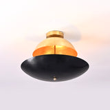 Artistic sculptural flushmount chandelier with warm inner glow, featuring a brass dome top and matte black bowl bottom.