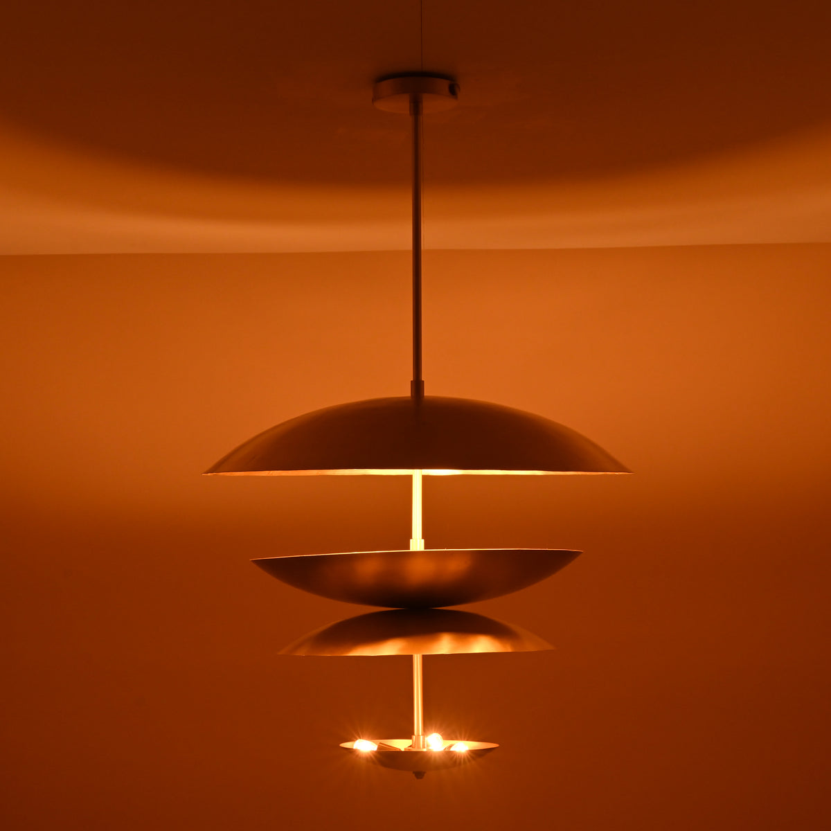 Warm ambient glow from triple bowl brass chandelier with brushed finish, handcrafted by Brass Leaf Studio