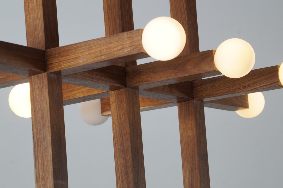 Close-up view of intersecting wooden beams and frosted bulbs on modern geometric chandelier – handcrafted detail by Brass Leaf Studio