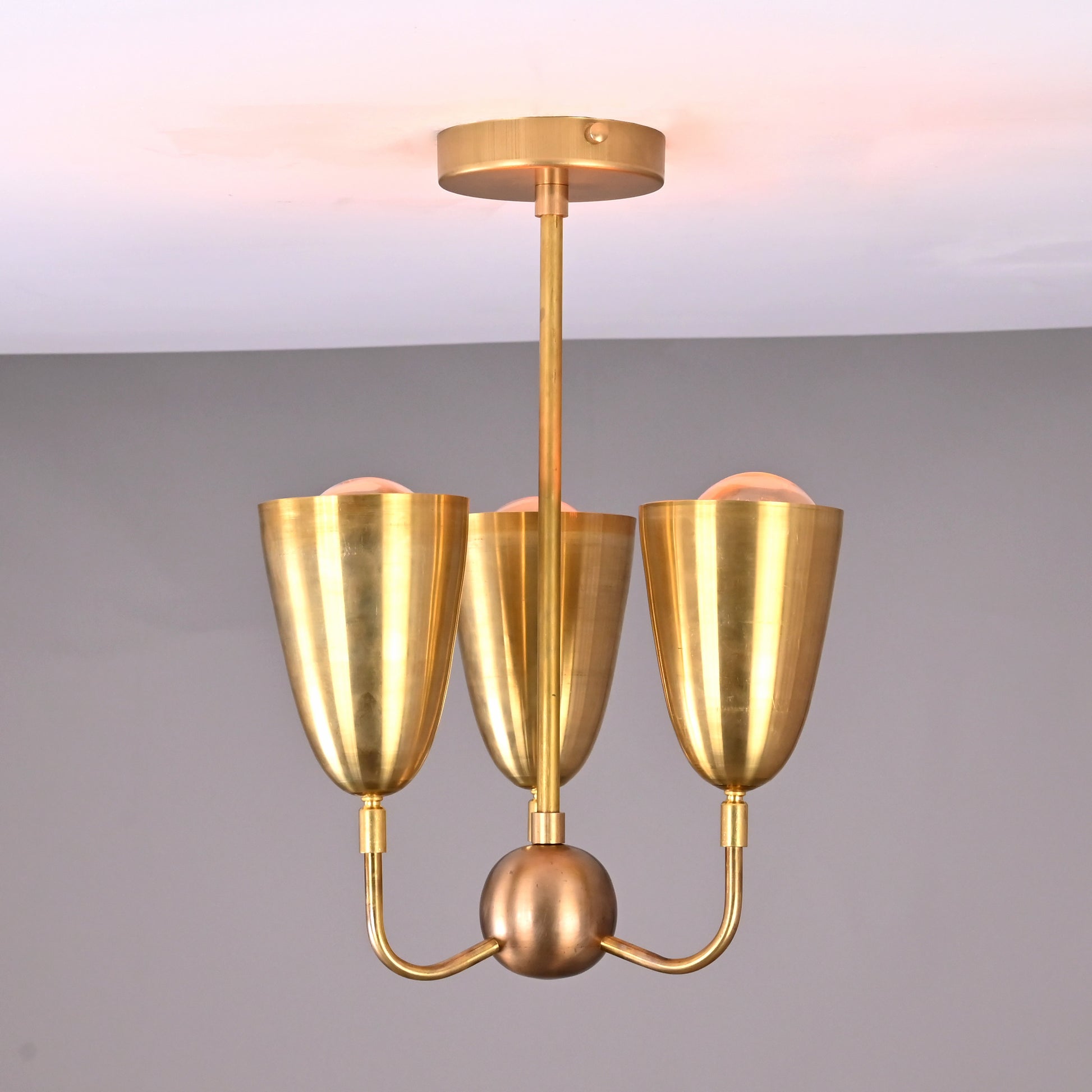 Bottom-up view of brass ceiling pendant showing cone symmetry and central hub